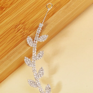 Détail d'un serre-tête de mariée en forme de feuilles avec strass et finition argentée polie