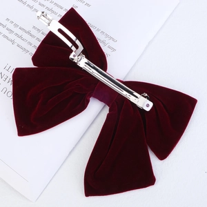 Close-up of the burgundy velvet bow hair clip showing the sturdy silver metal spring clip