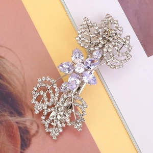 Dettaglio del fermaglio per capelli con fiore di cristallo viola e strass bianchi lucidi