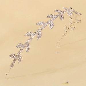 Détail d'un serre-tête argenté avec feuilles en strass blancs et boucles de fixation