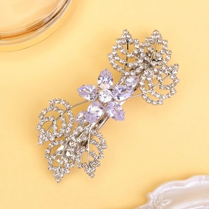 Dettaglio di un fermaglio per capelli a fiore in zircone viola con foglie in strass lucidi
