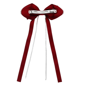 Detail of red velvet bow hair clip featuring sparkling long rhinestone tassel chains
