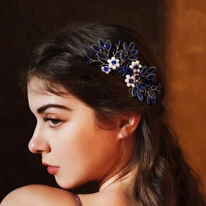 Detail of bridal hair comb with blue crystals and white pearls on elegant updo hairstyle