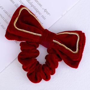 Detailed view of red velvet bow hair clip with sparkling rhinestone inner ring detail