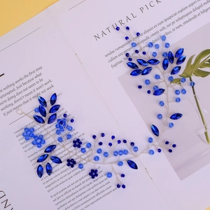 Vue détaillée des fleurs de cristal bleu faites à la main et perles de fil argenté sur serre-tête