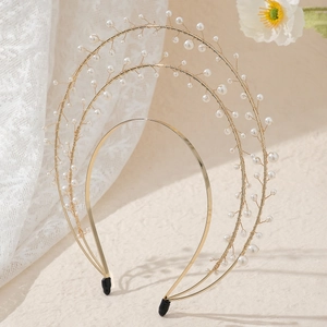 Detail of handcrafted golden three-layer halo crown with elegant faux pearls and gold wire