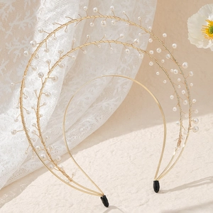 Detail of a double-layered golden halo headband with white pearls and branch motifs