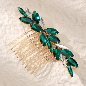 Détail d'un peigne à cheveux orné de feuilles en strass émeraude et base dorée