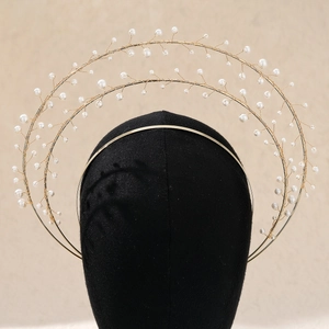 Detail of gold halo crown with tiered white pearls on a black display head