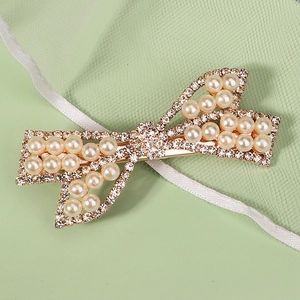 Vue détaillée de la pince à cheveux dorée ornée de strass brillants et de perles