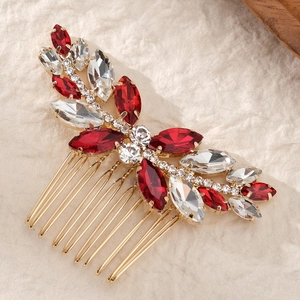 Détail d'un peigne à cheveux de mariée avec strass marquise rouges et clairs et dents dorées