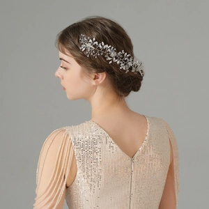 Close-up of handmade silver bridal hair comb with vine-like crystal and rhinestone details