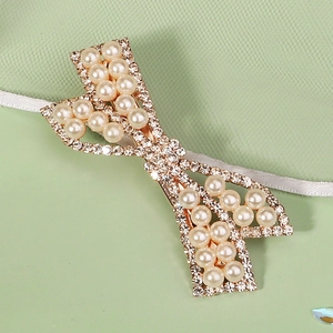 Détail d'une pince à cheveux élégante avec perles crème et strass scintillants