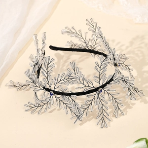 Elegant crystal bridal headband with dark blue gems and beaded branches on a warm beige backdrop
