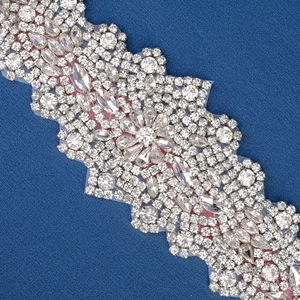 Close-up of sparkling silver bridal belt with crystal rhinestones on dark fabric