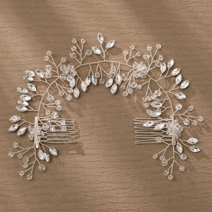 Close-up of handmade bridal hair comb with silver wire, crystals, and leaf design