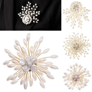 Detailed close-up of handmade pearl brooches in floral and wheat designs with gold wire