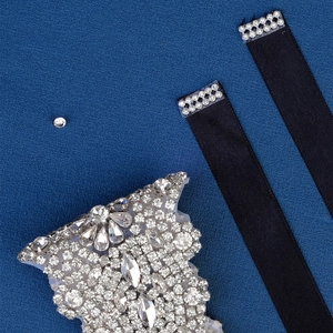 Detailed macro view of sparkling crystal appliqué with black silk ribbons for bridal belts