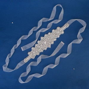 Elegant bridal wedding belt with ornate silver crystal floral pattern on white organza ribbon