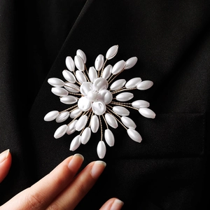 Detail of handcrafted floral pearl brooch pinned on a black suit lapel for elegant styling