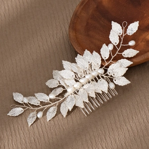 Detail of silver alloy leaves and white pearls on a handmade bridal hair comb accessory