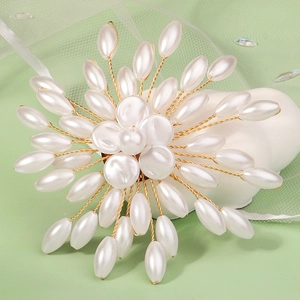 Handcrafted pearl flower brooch with white oval beads and gold wire on a soft green background