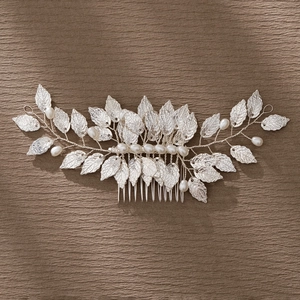 Detail of handmade silver alloy leaf hair comb with white pearls for bridal styling