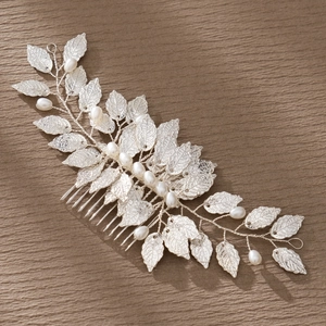 Detailed macro view of handmade silver leaf hair comb with white pearls for bridal styling