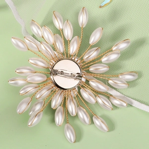 Close-up of handmade beaded sunflower brooch with pearls and metal pin backing
