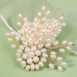 Detail of handcrafted bridal brooch with white pearls and gold twisted metal wire