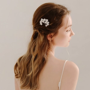 Détail de cinq épingles à cheveux à fleurs blanches faites main pour un chignon élégant