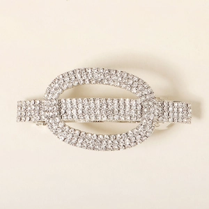 Macro detail of silver spring hair clip with sparkling rhinestones in oval design