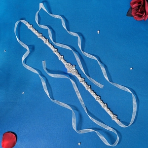Detail eines Brautgürtels mit Strass und Perlen auf weißem Chiffonband-Accessoire