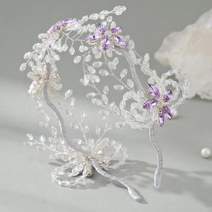 Close-up of handmade bridal headband with crystal flowers and silver beaded leaves