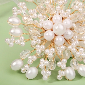 Detail view of handcrafted floral brooch featuring white faux pearls and faceted crystal beads