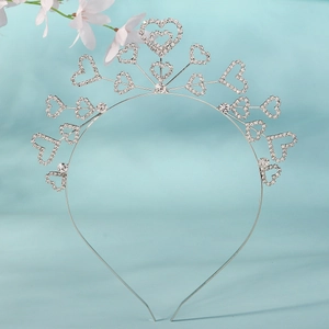 Détail de serre-tête de mariée argenté avec cœurs en strass sur fond bleu clair