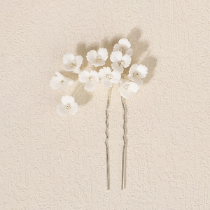 Détail de fleurs en argile polymère blanche avec perles sur une épingle à cheveux argentée