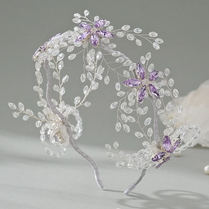 Macro detail of hand-woven silver wire headband with purple crystals and teardrop beads