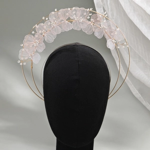 Détail des fleurs en maille et des pétales dorés faits main sur un serre-tête de mariée chic