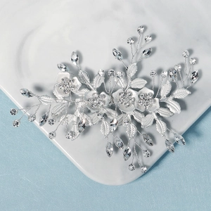 Détail d'une pince à cheveux de mariée faite main avec fleurs argentées et cristaux