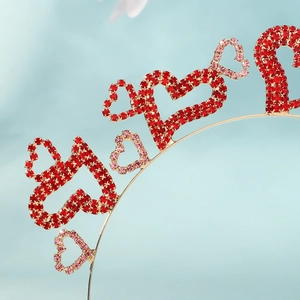 Gros plan de cœurs en strass rouges et roses sur un serre-tête doré de fête
