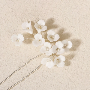 Détail macro de fleurs en pâte polymère blanche sur une épingle à cheveux argentée en U