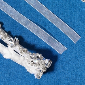 Detailansicht eines Brautgürtels mit Strasssteinen, Perlen und Organza-Stoffband