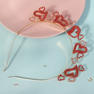 Détail d'un serre-tête doré orné de strass rouges et roses brillants en forme de cœur