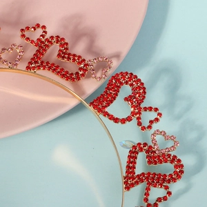 Détail de strass rouges et roses en forme de cœur sur un diadème doré