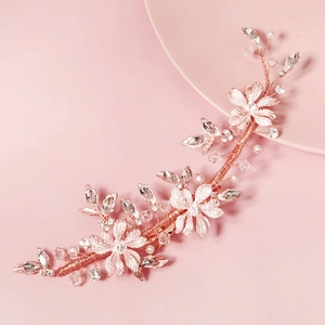 Detail von Brauthaarranke in Roségold mit Metallblumen, Kristallen und weißen Perlen