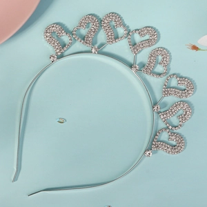 Détail d'un serre-tête argenté avec strass, motifs de cœur évidés et cristaux brillants