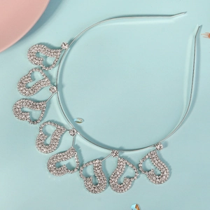 Détail d'un serre-tête argenté avec huit breloques en forme de cœur et strass brillants