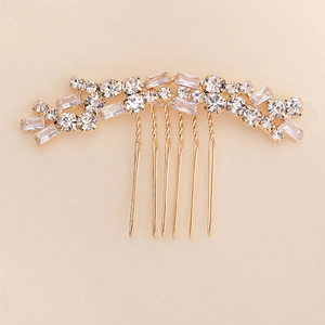 Detail of elegant gold hair comb featuring faceted zircons and twisted teeth