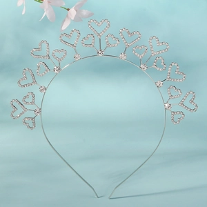 Détail macro du serre-tête argenté en forme de cœur orné de strass transparents brillants